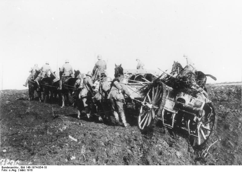 Soldados alemanes moviendo cañones y suministros a caballo por el terreno lodoso.